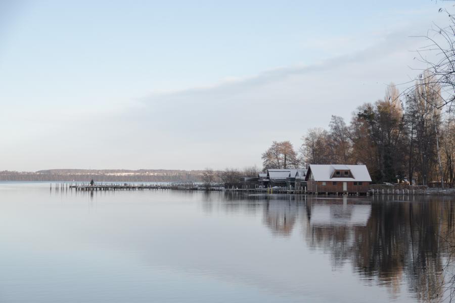 Schweriner See mit schneebedeckten Bootshäusern im Winter