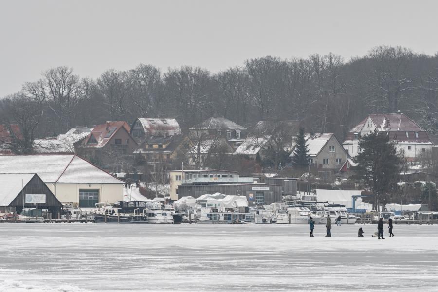 Heidensee im Winter mit schlittschuhfahrenden Kindern und Landschaft